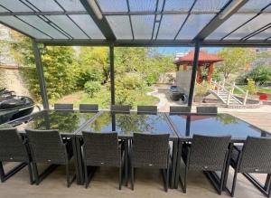 a patio with a glass table and chairs and a gazebo at Maison cozy 2p- Jardin - Paris à 5 min - Métro in Maisons-Alfort