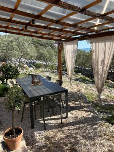 a black table and chairs under a wooden pergola at Mrdina house in Kali +33 photos