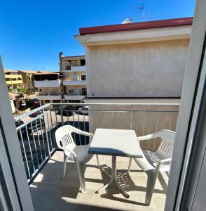 two chairs and a table on a balcony at Fortezza Apartments in Le Castella