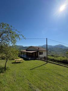 a house in a field with a fence and a tree at Alta Quiete in Frontone