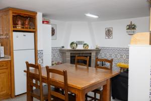 a kitchen with a wooden table and a fireplace at Casa da Castanha Sernancelhe in Sernancelhe