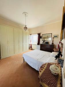 a bedroom with a large white bed and a table at Maison Artista in Procida