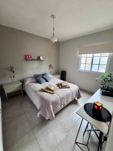 a bedroom with a large bed and a table at Casa Serena Rio in Viedma