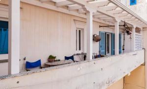 a porch of a house with blue chairs at Maison Artista in Procida