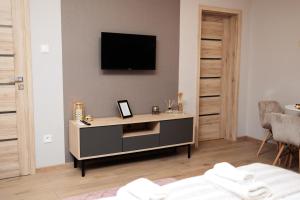 a living room with a tv on a wall at KB House apartman in Malý Horeš