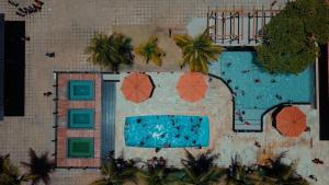 an overhead view of a swimming pool with umbrellas at Estância Costa do Sol in Nova Viçosa