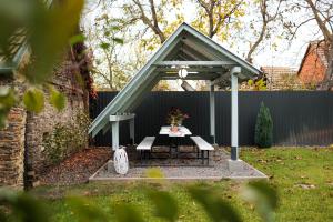 a picnic shelter with a table in a backyard at KB House apartman in Malý Horeš