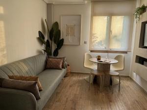 a living room with a couch and a table at BILBAO ENEA - Apartamento 2 habitaciones cerca de San Mamés in Bilbao +9 photos