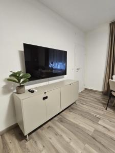 a living room with a flat screen tv on a white cabinet at Stadtoase Wels III in Wels