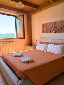 a bedroom with a large bed with towels on it at Alta Quiete in Frontone