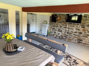 a room with a table and a tv on a brick wall at Вила Карапча in Stoyan Zaimovo
