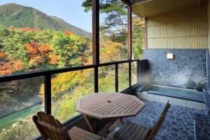 uma mesa e 2 cadeiras numa varanda com vista em Nanaeyae em Nikko