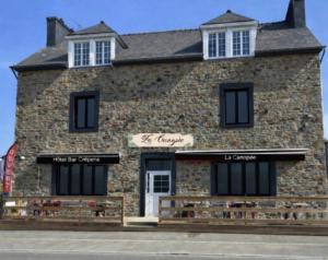 a brick building with two windows and a sign on it at La Canopée in La Gouesnière