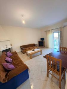 a living room with two beds and a table at Dimitris House in Pllakë
