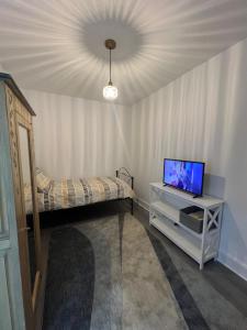 a bedroom with a bed and a tv on a table at Stylish Central Kettering Apartment by SJP in Kettering