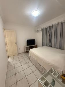 a small room with a bed and a television at Natal Exclusive Pool Villa Private Community in Natal