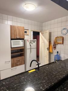 a kitchen with a sink and a white refrigerator at Natal Exclusive Pool Villa Private Community in Natal