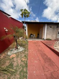 a palm tree in front of a red building at Natal Exclusive Pool Villa Private Community in Natal