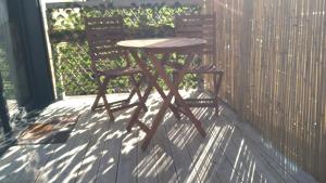 a wooden table and two chairs on a porch at L'Insolite in Melun