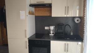 a kitchen with white cabinets and a black counter top at L'Insolite in Melun