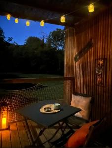 a table and a chair on a patio at night at Tiny House nature & détente, Vercors, terrasse, vue montagne in La Motte-Fanjas