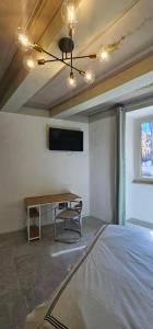 a room with a bed and a table and a tv at HOUSE Sant'Angelo in Acquapendente