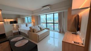 a bedroom with a bed and a chair and a television at Tropical Executive Hotel 804 - Propriedade Particular in Manaus