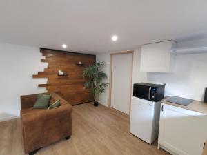 a living room with a couch and a kitchen at Appartement - Cestas in Cestas