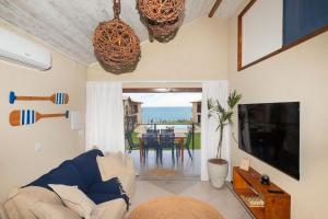 a living room with a couch and a television and a table at Coleção Falésias de Pipa- by Arcbio Experience in Pipa