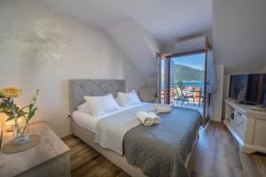 a bedroom with a bed with a view of the ocean at Apartments Nikčević in Kotor +49 photos