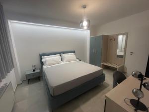 a bedroom with a bed and a desk with a computer at Gheloi Room in Gela