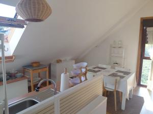 a kitchen with a sink and a table with chairs at Ático en Ribeira Ría de Arousa in Ribeira