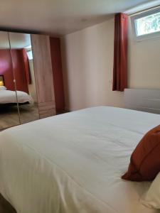 a large white bed in a room with a window at Appartement - Cestas in Cestas +1 photo