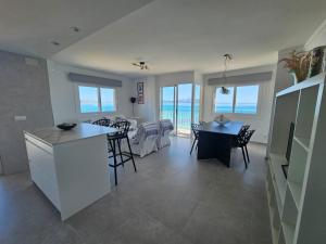 a kitchen and dining room with a view of the ocean at Hawaii Beach Can Picafort in Can Picafort