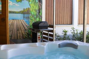 a bathroom with a tub and a grill on a deck at Bakony Kincse Vendégház in Jásd