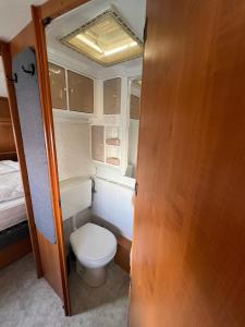 a small bathroom with a toilet in an rv at Campingurlaub Sehlendorf in Blekendorf +20 photos