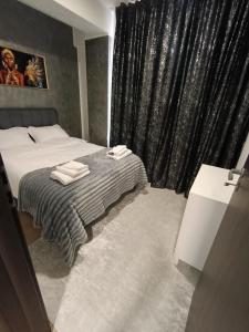 a bedroom with a bed and a black curtain at Apartament Maya luxury in Bucharest