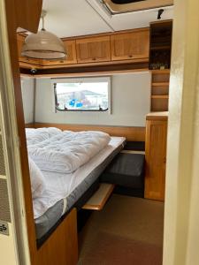 a small bedroom with a bed in an rv at Campingurlaub Sehlendorf in Blekendorf