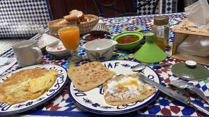 a table with two plates of breakfast food on it at Dar El Mathaf FES El BALI in Fez
