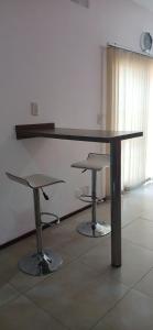 a table and two stools in a room at Casa en planta alta in Rosario