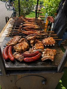 a grill with a bunch of meat and sausages at Baťův kanál Babice1 glamping in Babice