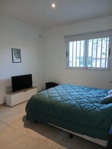 a bedroom with a bed and a television and a window at Monoambiente en el centro de Zarate in Zárate