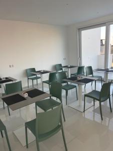 a group of tables and chairs in a room at Gheloi Room in Gela