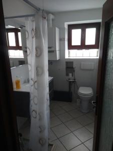 ein Badezimmer mit Toilette, Waschbecken und zwei Fenstern in der Unterkunft CA d'ADUA in Pray + 5 Fotos