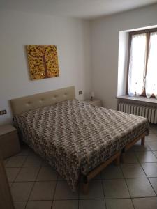 ein Schlafzimmer mit einem Bett mit Bettdecke und zwei Fenstern in der Unterkunft CA d'ADUA in Pray