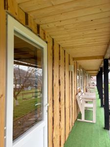 a covered porch of a house with a white door at Карпатські Мандри in Verkhovyna +21 photos
