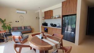a living room with a table and a kitchen at Chic apartment in Aldea Mayab with Lagoon access and private splash pool in Xul-Ha