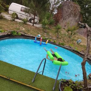 a large swimming pool with a person in an inflatable at Alojamento 444 in Monção