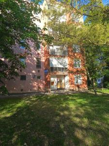 a large brick building with trees in front of it at JÁZMIN magán szállás in Makó