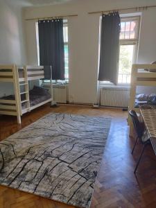 a room with two bunk beds and a rug at Hostel Latin Bridge in Sarajevo